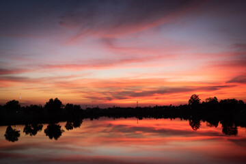Fototapeta na wymiar Sunset over lake with red orange sky.