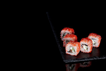 Philadelphia roll with salmon, cheese and cucumber on a black background with reflection. Sushi Philadelphia