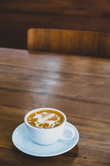 A cup of cappucino on a wood background