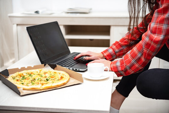 remote work on laptop with a cup of drink and pizza
