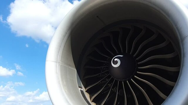 Jet turbine engine of aircraft rotating by wind with clouds and blue sky background.Aviation industry affected by coronavirus pandemic aircraft had to stop all flight plan.