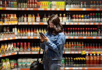 woman do grocery shopping checking list on the phone