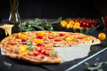 Pizza margarita with mozzarella cheese and tomatoes on a dark background, top view, flat lay