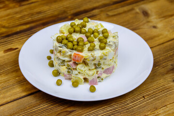 Traditional Russian festive salad Olivier on wooden table