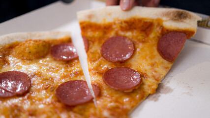 Young woman eats a pizza from delivery service while at work - home shooting