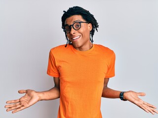 Young african american man wearing casual clothes and glasses clueless and confused expression with...