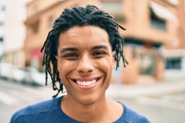Young african american man smiling happy looking to the camera at street of city. © Krakenimages.com