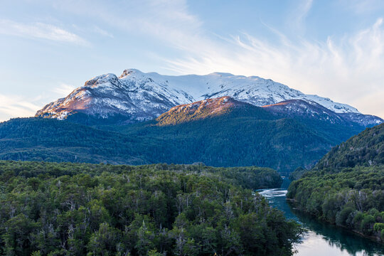 Landscape view of Arrayanes river against snowcapped Andes Mountains in Los Alerces National Park, Patagonia, Argentina