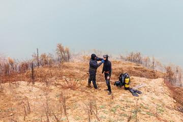 Lifeguard in a wetsuit to work underwater. Search at the bottom of the pond.