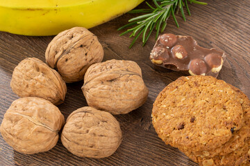 Walnuts, cookies and chocolate on a brown wooden kitchen table