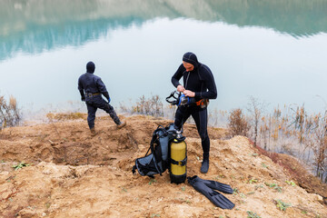 Lifeguard in a wetsuit to work underwater. Search at the bottom of the pond.