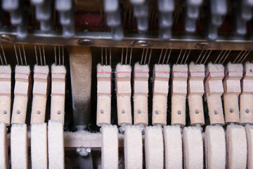 Naklejka premium Mechanics hammer close up inside of an upright piano, inside of an old piano before tuning