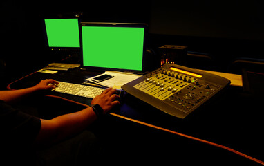 Sound engineer working in digital audio and video editing post production studio.Green...