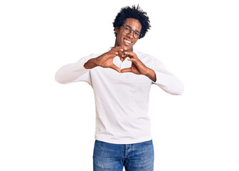 Handsome african american man with afro hair wearing casual clothes and glasses smiling in love doing heart symbol shape with hands. romantic concept.