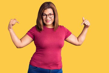 Middle age latin woman wearing casual clothes and glasses looking confident with smile on face, pointing oneself with fingers proud and happy.