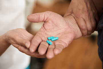 Blue medical capsules in male hand. Close up view of male hand holding pills in the palm. People, medicine and healthcare concept.