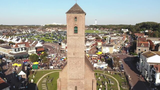 Church tower in Wijk aan Zee, coastal town in the Netherlands . Aerial dolly out