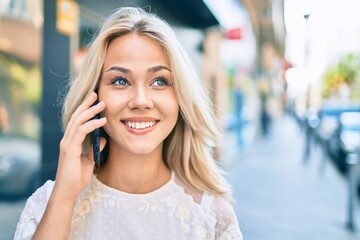 Young caucasian girl smiling happy using smartphone at street of city.