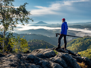 Obraz premium Professional photographer check location on cliff. Nature photographer carry camera