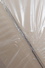 close-up of a cardboard box packed in polyethylene