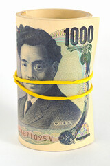 A bundle of Japanese 1000 yen bills stands on a white paper background. Banknotes are rolled up and tied with an elastic band. Roll of money. Vertical illustration. Bank deposit or loan. Macro