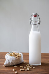 Fresh homemade cashew milk in a glass bottle with cashews in cotton bag. Eco-friendly kitchen products. Zero waste sustainable plastic free lifestyle
