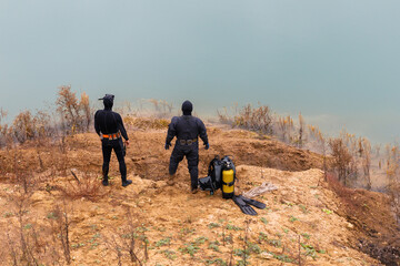 Lifeguard in a wetsuit to work underwater. Search at the bottom of the pond.