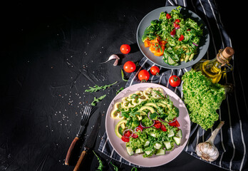 Healthy vegetable salad of fresh tomato, green leaves mix and vegetables. Top view on dark bacground. Diet menu