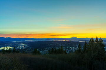 Spectacular sunrise over Fraser Valley with alpine mountains in silhouette on horizon