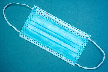 Antibacterial medical mask of blue color on a blue background. Coronavirus Protection concept.