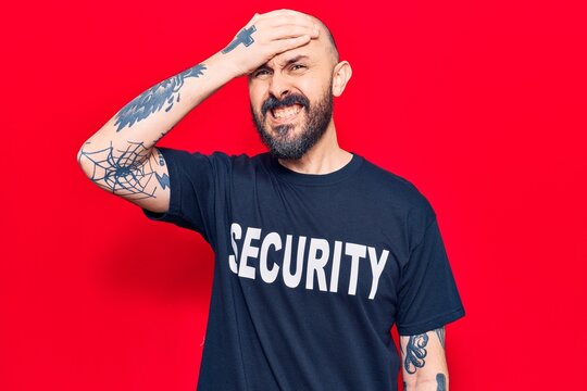 Young handsome man wearing security t shirt stressed and frustrated with hand on head, surprised and angry face