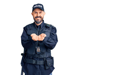 Young handsome man wearing police uniform smiling with hands palms together receiving or giving gesture. hold and protection