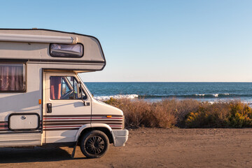 Spain; Nov 2020: Vintage caravan parked in front of the ocean, holidays and freedom feelings. Old...