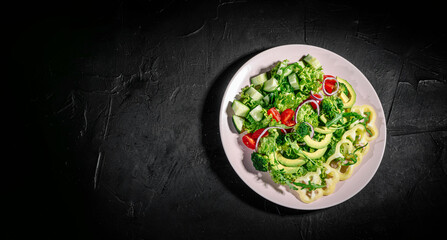 Healthy vegetable salad of fresh tomato, green leaves mix and vegetables. Top view on dark bacground. Diet menu