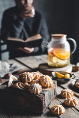 Woman is reading and Hot tea with fresh grapefruit on wooden tablet. Healthy drink, Eco
