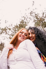 Fototapeta premium two girls with long hair having fun in the park, autumn outfit.Two pretty stylish women have fun 