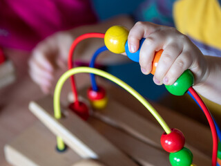 Dziecko bawiące się drewniana zabawka, kolorowe koraliki 