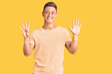 Young handsome man wearing casual clothes showing and pointing up with fingers number nine while...