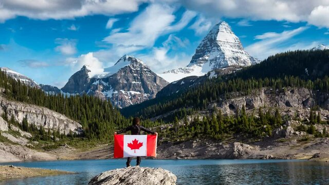 Cinemagraph Continuous Loop Animation. Girl Holding a Canadian National Flag. Beautiful View of Og Lake in the Iconic Mt Assiniboine Provincial Park near Banff, Alberta, Canada. Mountain Landscape