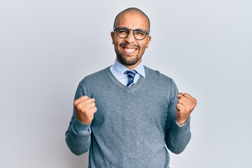 Hispanic adult man wearing glasses and business style excited for success with arms raised and eyes closed celebrating victory smiling. winner concept.