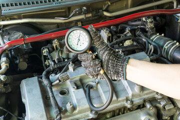 Obraz premium Auto mechanic use compression meter to measure car cylinder compression, Car maintenance service.