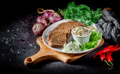 Appetizer meat pate with brown bread croutons on dark background