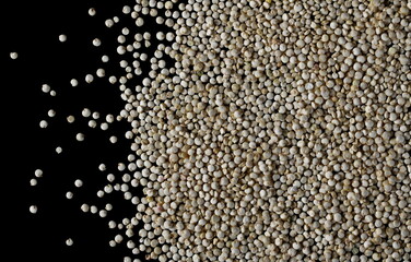 Organic quinoa seeds isolated on black background, top view