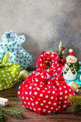 Christmas gifts furoshiki on wooden table. Eco christmas holiday concept. Copy space.