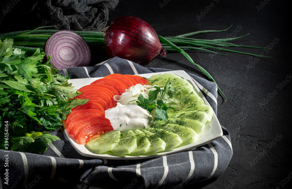 Wall mural Tomatoes and cucumbers vitamin salad on dark background. Healthy food concept