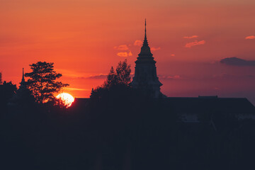 Fototapeta premium View over the temples of Chaiyaphum in Thailand to the surrounding mountains at sunset