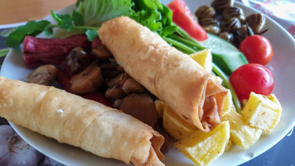 Plate of breakfast with vegetable rolls, mushrooms and salad