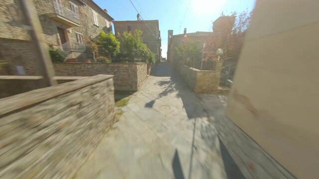 Aerial view, fast dolly forward between old alleys of an Italian village. Tuscany. Fpv Drone view