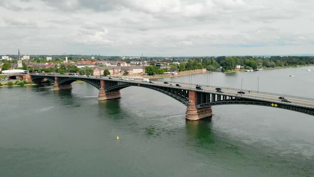 Aerial view overlooking cars on a the Theodor Heuss bridge, cloudy day, on Rhein river, in Mainz, Germany - rising, drone shot