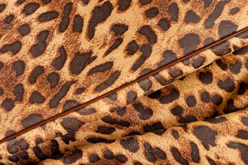 Genuine leather texture embossed under skin pattern of leopard, exotic fashion trend, jungle background